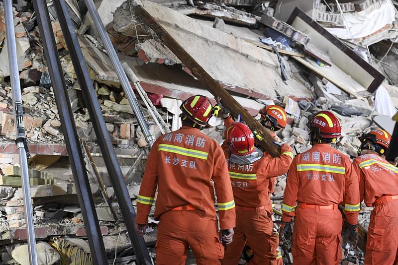 This photo taken on 29 April, 2022 shows rescuers searching for survivors at a collapsed six-storey building in Changsha, central China’s Hunan province