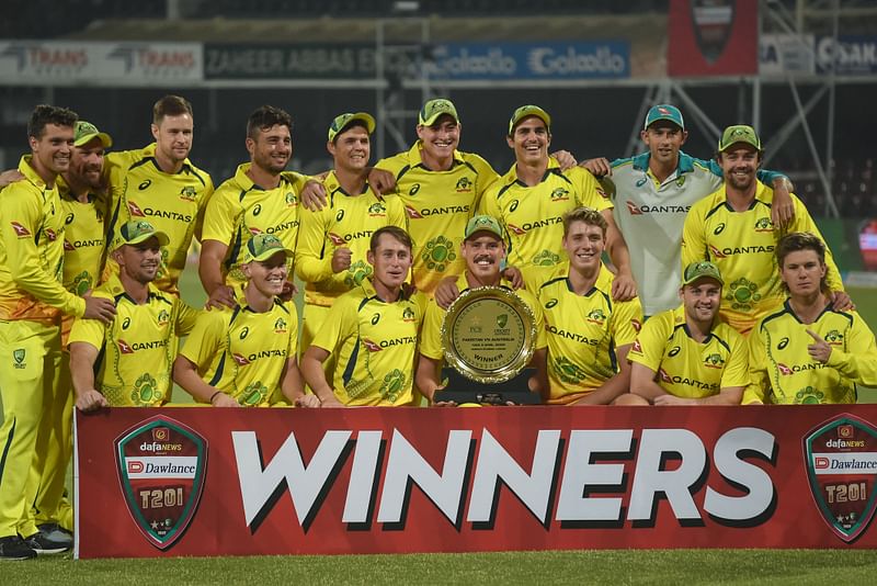 Australia's players pose with the trophy after winning the Twenty20 international cricket match between Pakistan and Australia at the Gaddafi Cricket Stadium in Lahore on 6 April, 2022