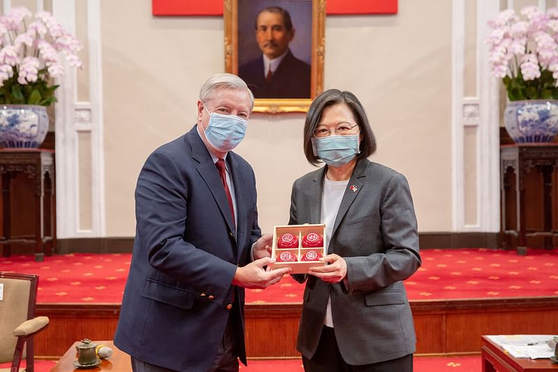 This handout picture taken and released by Taiwan’s Presidential Office shows US Senator Lindsey Hraham (L) receiving a gift from Taiwan President Tsai Ing-wen on 15 April, 2022