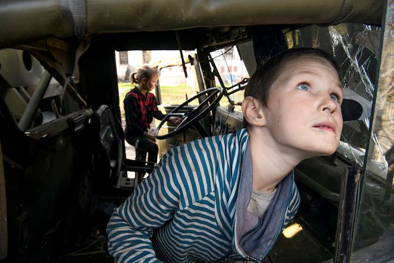 Local boy Faddei plays in a destroyed Russian military truck in the village of Kolychivka, in Chernihiv region, Ukraine.