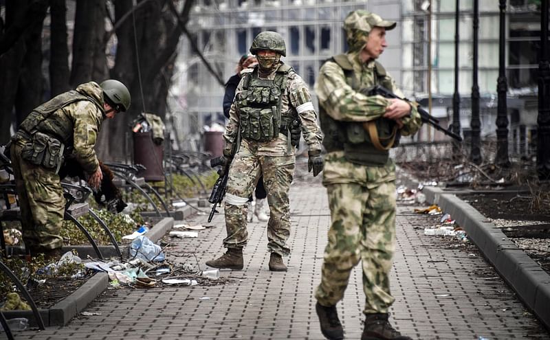 Russian soldiers walks along a street in Mariupol on 12 April, 2022, as Russian troops intensify a campaign to take the strategic port city