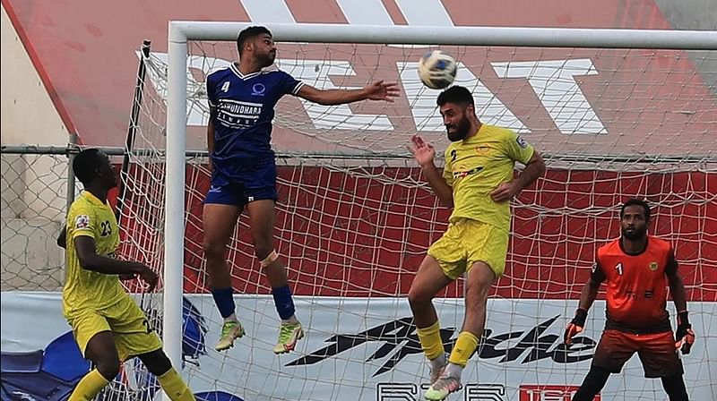 Rahamatganj MFS’ centre back Siyovush Asrorov clears the ball during a BPL football match against Sheikh Russel Krira Chakra on 4 April, 2022