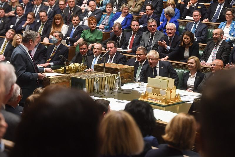 A handout photograph released by the UK Parliament shows Britain's Prime Minister Boris Johnson (centre right) reacting to Britain's main opposition Labour Party leader Keir Starmer (L) during prime minister's questions in the House of Commons in London on 20 April, 2022