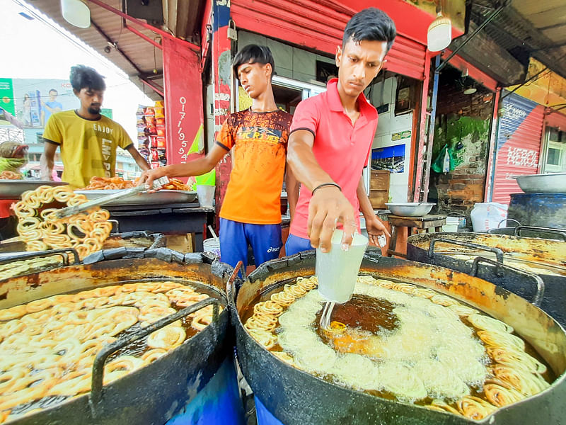 Two youths make delicious Reshmi jilapi, tradition sweet for Bangladesh in Ramadan, for sale at Tk 300 per kilogram.  The picture was taken from Ferryghat intersection in Khulna on 5 April.