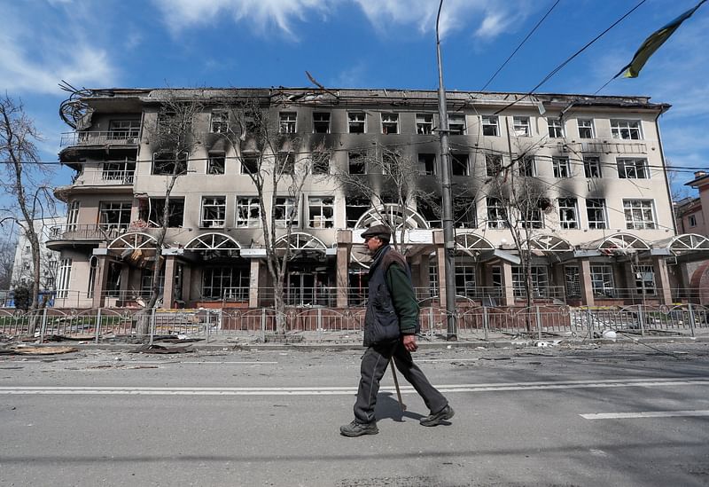 A resident walks near a building destroyed in the course of the Ukraine-Russia conflict, in the southern port city of Mariupol, Ukraine on 10 April, 2022