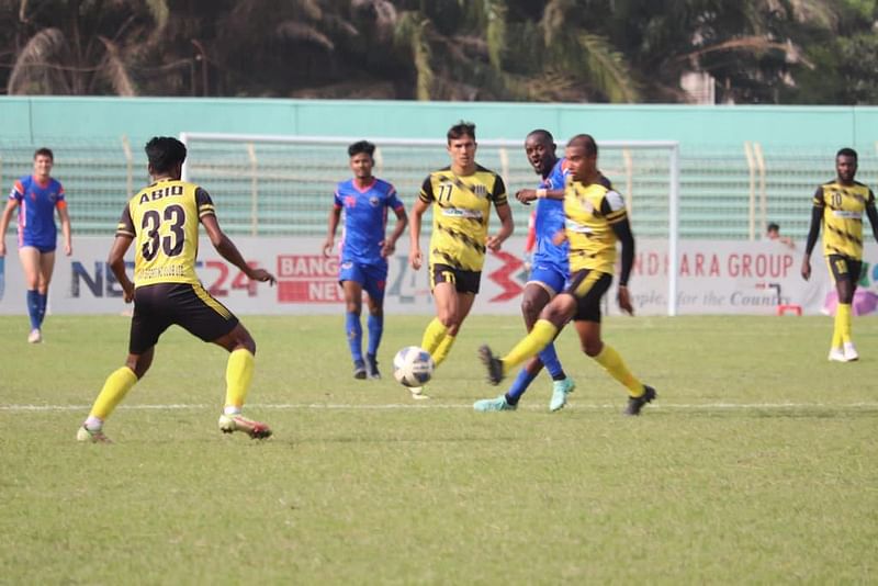 Saif Sporting Club's Jamal Bhuyan passes the ball during the BPL football match against Bangladesh Police FC at the  Muktijoddha Smrity Stadium in Rajshahi on 25 April, 2022