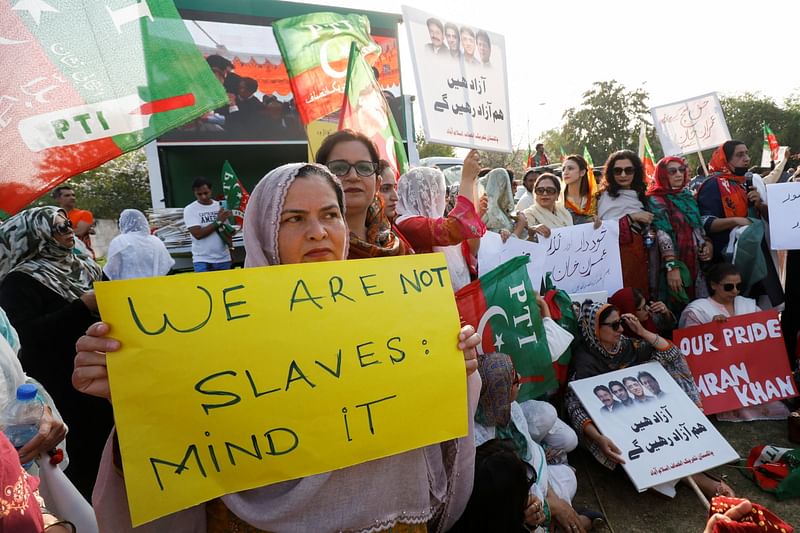 Supporters of the Pakistan Tehreek-e-Insaf (PTI) carry signs as they chant slogans accusing the U.S. of plotting to overthrow Pakistani Prime Minister Imran Khan, during a protest in Islamabad, Pakistan 2 April, 2022