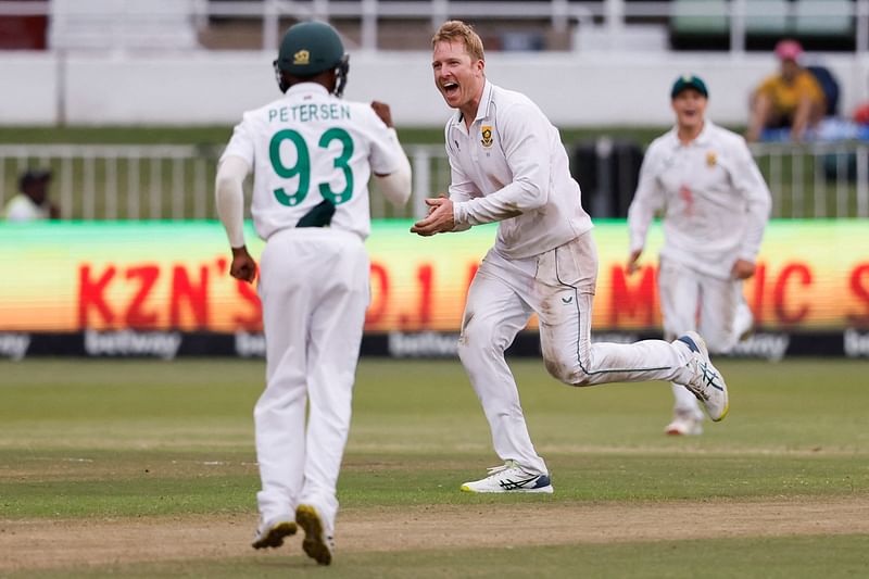 South Africa's Simon Harmer (C) celebrates after the dismissal of Bangladesh's Mushfiqur Rahim (not seen) during the second day of the first Test cricket match between South Africa and Bangladesh at the Kingsmead stadium in Durban on 1 April 2022