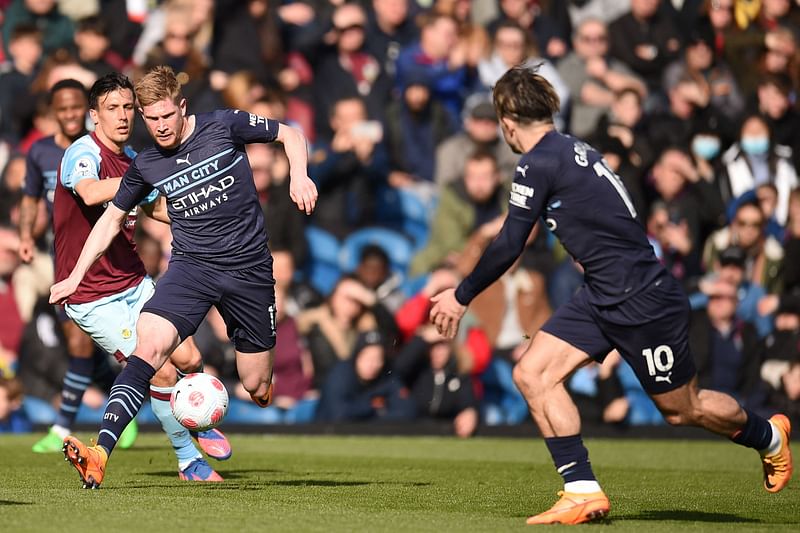 Manchester City's Belgian midfielder Kevin De Bruyne (3rd L) skips past Burnley's English midfielder Jack Cork (2nd L) as Manchester City's English midfielder Jack Grealish (R) waits for the ball during the English Premier League football match between Burnley and Manchester City at Turf Moor in Burnley, north west England on 2 April, 2022