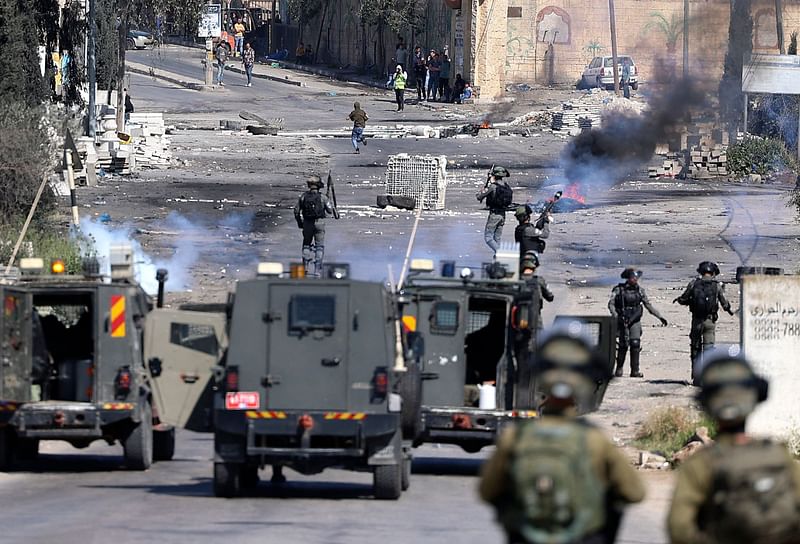 Israeli security forces fire tear gas during clashes with Palestinian protesters following a demonstration against Jewish settlements and in support of Jerusalem's Al-Aqsa mosque, on the main street of Beita village in the occupied West Bank, on 15 April, 2022