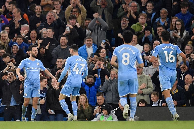 Manchester City's Portuguese midfielder Bernardo Silva (L) celebrates with teammates after scoring his team third goal during the English Premier League football match between Manchester City and Brighton and Hove Albion at the Etihad Stadium in Manchester, north west England, on 20 April, 2022