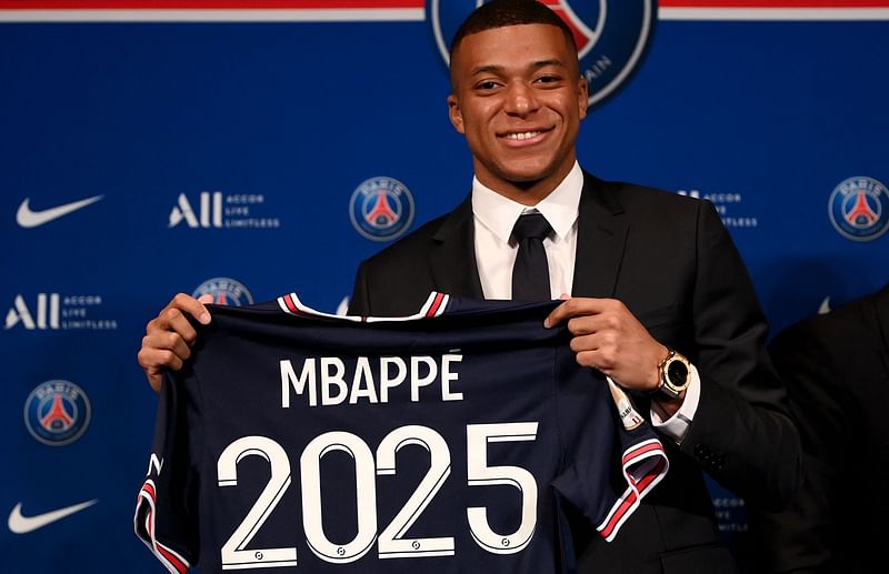 Paris Saint-Germain's French forward Kylian Mbappe poses with a jersey