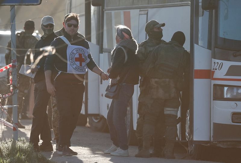 People stand next to a bus carrying civilians, who were evacuated from Mariupol in the course of Ukraine-Russia conflict, near a temporary accommodation centre in the village of Bezimenne in the Donetsk region, Ukraine on 7 May 2022.