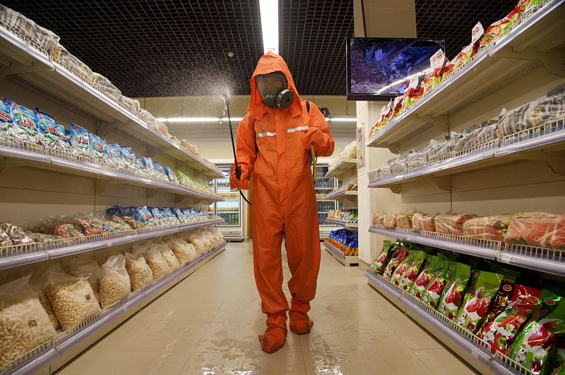 In this file picture taken on 27 September, 2021, a health official sprays disinfectant as part of preventative measures against Covid-19, in the Daesong Department Store in Pyongyang.