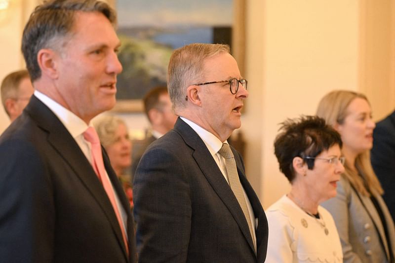 Australian new Prime Minister Anthony Albanese (C) sings the national anthem with his cabinet ministers during a swearing-in ceremony at Government House in Canberra on 23 May, 2022