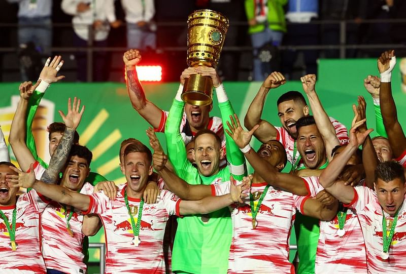 RB Leipzig's Peter Gulacsi lifts the trophy as he celebrates winning the final with teammates