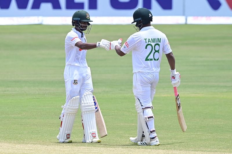 Bangladesh's Mahmudul Hasan Joy (L) celebrates after scoring a half-century (50 runs) with his teammate Tamim Iqbal (R) during the third day of the first Test cricket match between Bangladesh and Sri Lanka at the Zahur Ahmed Chowdhury Stadium in Chittagong on 17 May 2022