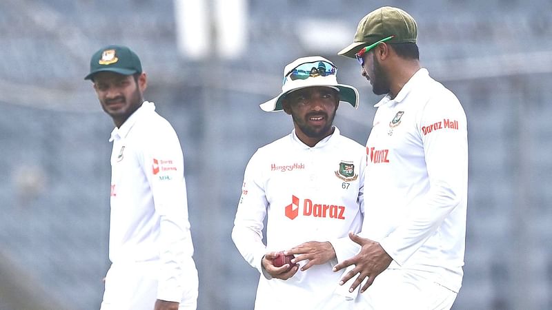 Bangladesh's Shakib Al Hasan (R) and Bangladesh's captain Mominul Haque (C) talk during the fourth day of the second Test cricket match between Bangladesh and Sri Lanka at the Sher-e-Bangla National Cricket Stadium in Dhaka on 26 May 2022