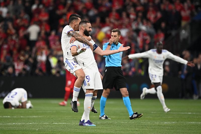 Real Madrid's Spanish midfielder Daniel Cebellos (L) and Real Madrid's French striker Karim Benzema (R) celebrate Real Madrid's victory in the UEFA Champions League final football match between Liverpool and Real Madrid at the Stade de France in Saint-Denis, north of Paris, on 28 May, 2022