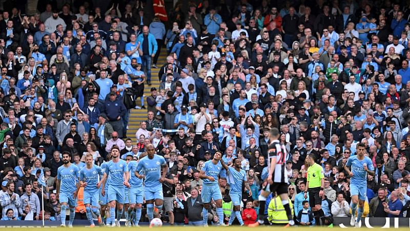 Manchester City's Spanish midfielder Rodri (C) celebrates scoring the team's third goal with Manchester City's English midfielder Raheem Sterling during the English Premier League football match between Manchester City and Newcastle United at the Etihad Stadium in Manchester, north west England, on 8 May, 2022