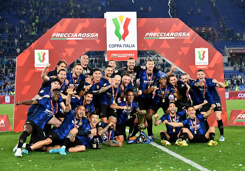 Inter Milan's Argentine forward Lautaro Martinez (C) and Inter players celebrate with the winner's trophy after Inter won the Italian Cup (Coppa Italia) final football match between Juventus and Inter on 11 May, 2022