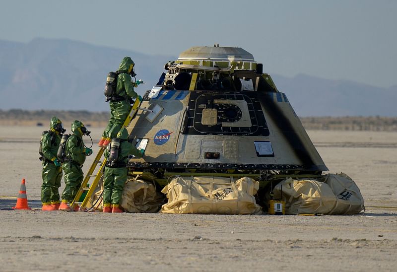 In this handout image courtesy of NASA, Boeing and NASA teams work around Boeing’s CST-100 Starliner spacecraft after it landed at White Sands Missile Range’s Space Harbor, 25 May, 2022, in New Mexico