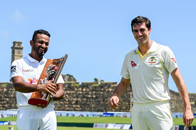 Sri Lanka's captain Dimuth Karunaratne (L) and Australia's captain Pat Cummins pose with Warne–Muralitharan Test trophy at the Galle International Cricket Stadium in Galle on June 28, 2022