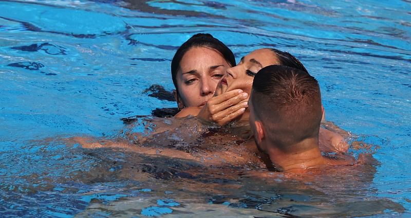 A member of Team USA (L) recovers USA's Anita Alvarez (C), from the bottom of the pool during an incendent in the women's solo free artistic swimming finals, during the Budapest 2022 World Aquatics Championships at the Alfred Hajos Swimming Complex in Budapest on 22 June, 2022