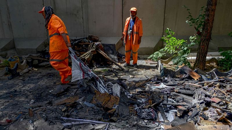 Afghan municipal workers clean the debris from inside a compound of a Sikh temple in Kabul on 20 June 2022