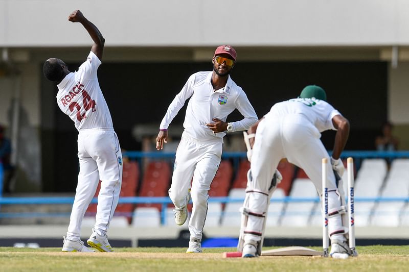 Kemar Roach (L) and Kraigg Brathwaite (C), of West Indies, celebrate the dismissal of Ebadot Hossain Chowdhury (R), of Bangladesh, during the third day of the 1st Test between Bangladesh and West Indies at Vivian Richards Cricket Stadium in North Sound, Antigua and Barbuda, on 18 June, 2022