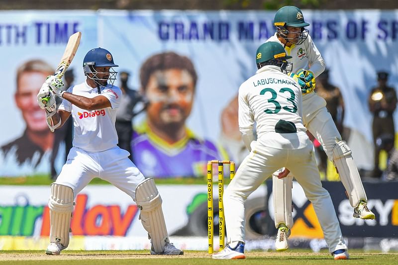 Sri Lanka’s captain Dimuth Karunaratne (L) watches the ball after playing a shot during the first day of the first cricket Test match between Sri Lanka and Australia at the Galle International Cricket Stadium in Galle on 29 June, 2022