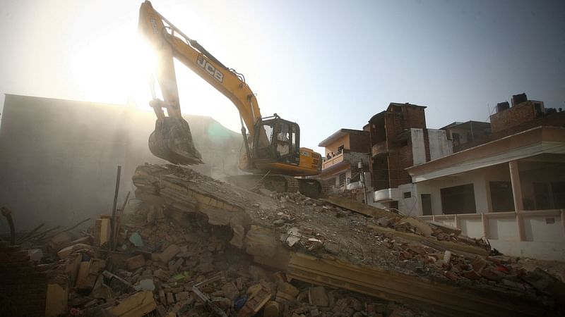 A bulldozer demolishes the house of a Muslim man that Uttar Pradesh state authorities accuse of being involved in riots last week, that erupted following comments about Prophet Mohammed by India's ruling Bharatiya Janata Party (BJP) members, in Prayagraj, India, on 12 June 2022