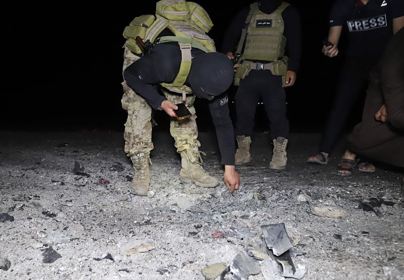 Fighters affiliated with the Hayat Tahrir al-Sham (HTS) jihadist group in Syria inspect the site of a reported drone attack which targeted a motorcycle on the eastern edge of Syria's rebel-held Idlib province, early on 28 June, 2022