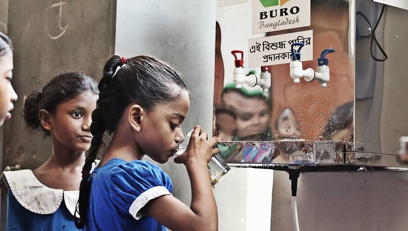 A girl drinks water at a school