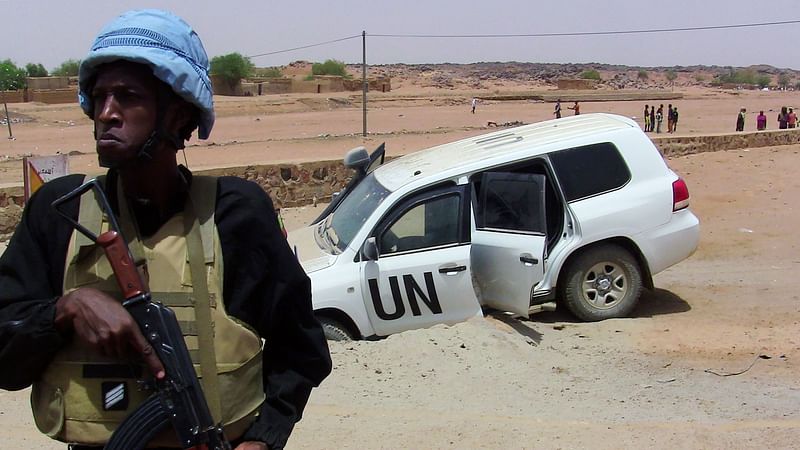 In this file photo taken on 16 July, 2016 shows a soldier of the United Nations mission to Mali MINUSMA standing guard near a UN vehicle after it drove over an explosive device near Kidal, northern Mali