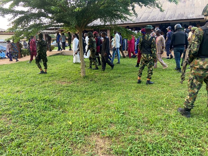 Security men guard Ondo State Governor Rotimi Akeredolu as he visits the victims of a bomb attack at St Francis Catholic church, in Owo, Nigeria, 5 June, 2022.