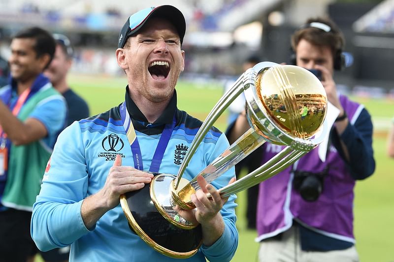 In this file photo taken on 14 July, 2019 England's captain Eoin Morgan celebrates with the World Cup trophy on the pitch after the 2019 Cricket World Cup final between England and New Zealand at Lord's Cricket Ground in London