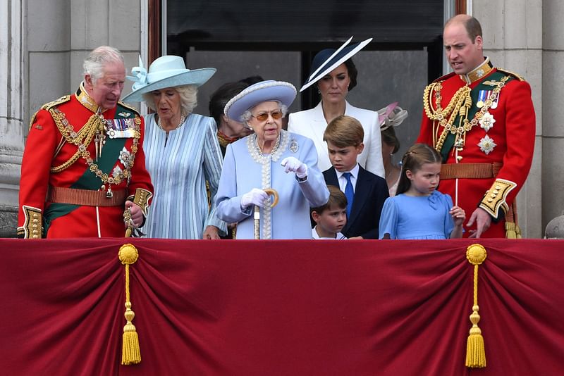 Britain's Queen Elizabeth II (C) stands with from left, Britain's Prince Charles, Prince of Wales, Britain's Prince Louis of Cambridge, Britain's Catherine, Duchess of Cambridge, Britain's Prince George of Cambridge, Britain's Princess Charlotte of Cambridge, and Britain's Prince William, Duke of Cambridge, to watch a special flypast from Buckingham Palace balcony following the Queen's Birthday Parade, the Trooping the Colour, as part of Queen Elizabeth II's platinum jubilee celebrations, in London on June 2, 2022