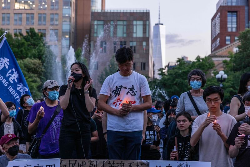 Attendees gather around a banner to pose for a photo during a vigil to mark the 33rd anniversary of the Tiananmen Square massacre in New York, on 4 June, 2022.