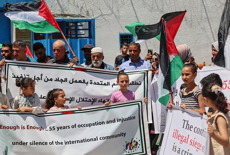 Palestinians take part in a protest commemorating the capture of the Gaza Strip by Israel 55 years ago and its 15th year of blockade, in front of the United Nations Educational, Scientific and Cultural Organization (UNESCO) headquarters in Gaza city on 14 June, 2022