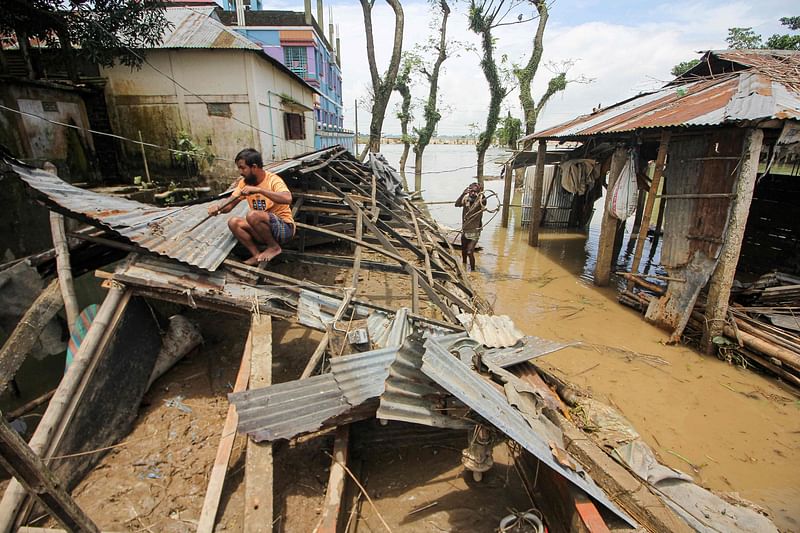 A man fixes his house that was damaged in recent floods in Companiganj in Sylhet on 24 June 2022