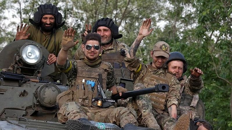 Ukrainian servicemen wave as they ride atop an armoured fighting vehicle, amid Russia's attack on Ukraine, in Donetsk region, Ukraine June 8, 2022.