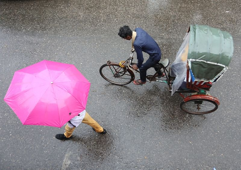 A pedestrian protects himself from rain in Ambarkhan, Sylhet, 13 June 2022. Incessant rain has disrupted people’s daily lives for the past several days.