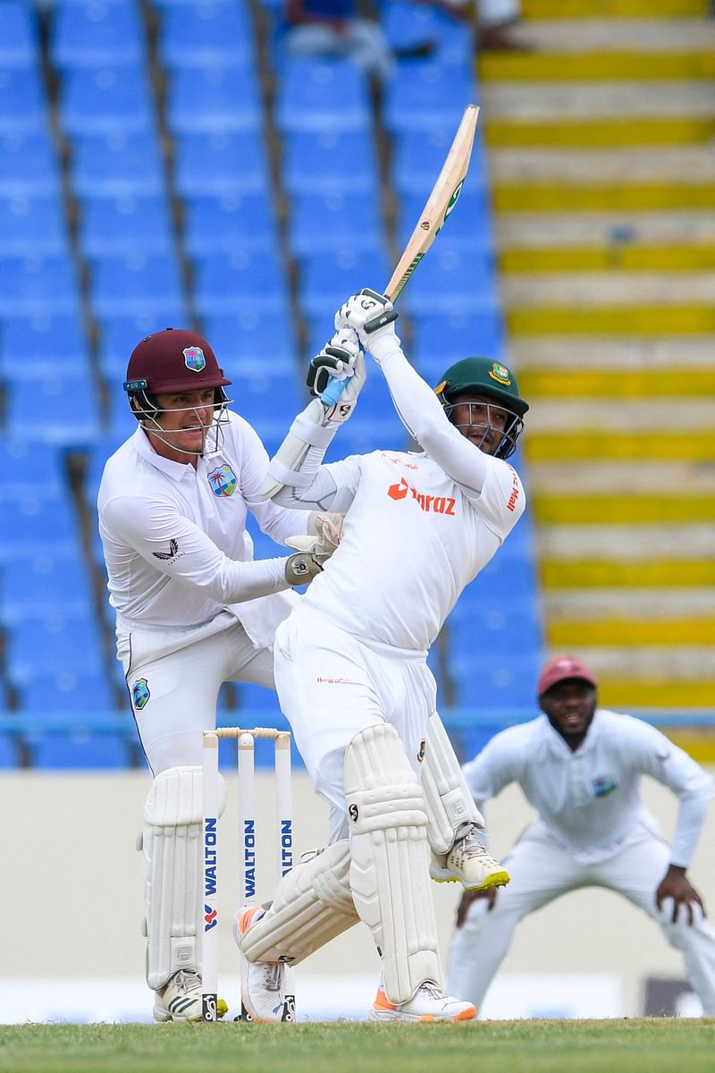 Shakib Al Hasan (R) of Bangladesh hits 6 as Joshua Da Silva (L) of West Indies watches during the 1st day of the 1st Test between Bangladesh and West Indies at Vivian Richards Cricket Stadium in North Sound, Antigua and Barbuda, on 16 June  2022.