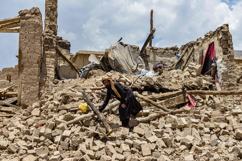 An Afghan man looks for his belongings amid the ruins of a house damaged by an earthquake in Bermal district, Paktika province on 23 June, 2022