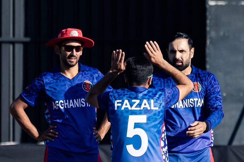 Afghanistan's Mohammad Nabi celebrates with teammates after taking a wicket during the second T20I match against Zimbabwe at the Harare Sports Club in Harare on 12 June, 2022