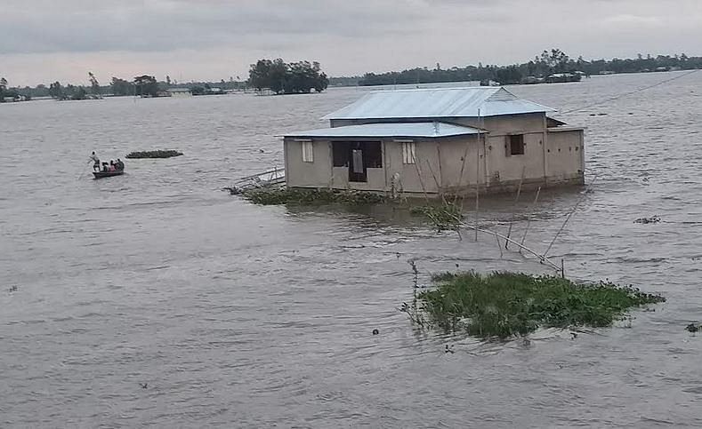 People leave by boat as floodwater submerges houses