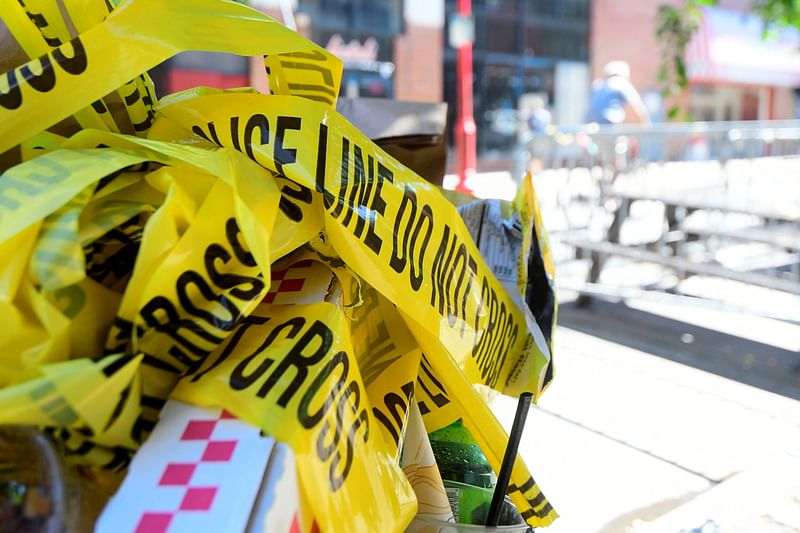 Police tape is pictured at a trash can on the street, at a crime scene after a deadly mass shooting on South Street in Philadelphia, Pennsylvania, US