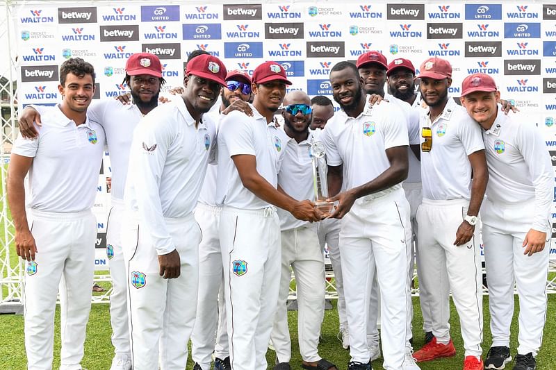 Members of the West Indies team stand for a photo with the trophy after winning on the fourth day of the 2nd Test between Bangladesh and West Indies at Darren Sammy Cricket Ground in Gros Islet, Saint Lucia, on 27 June, 2022