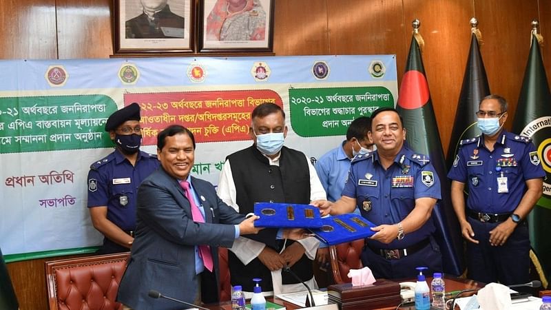 Home minister Asaduzzaman Khan Kamal hands over the award to IGP Benazir Ahmed at the home ministry’s conference room on 27 June 2022